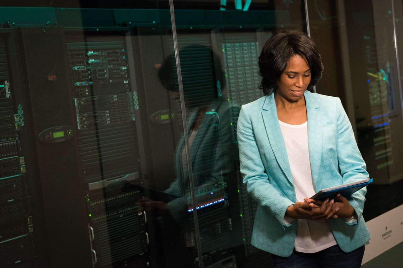 Crafting Captivating Headlines: Your awesome post title goes here Female IT professional examining data servers in a modern data center setting.