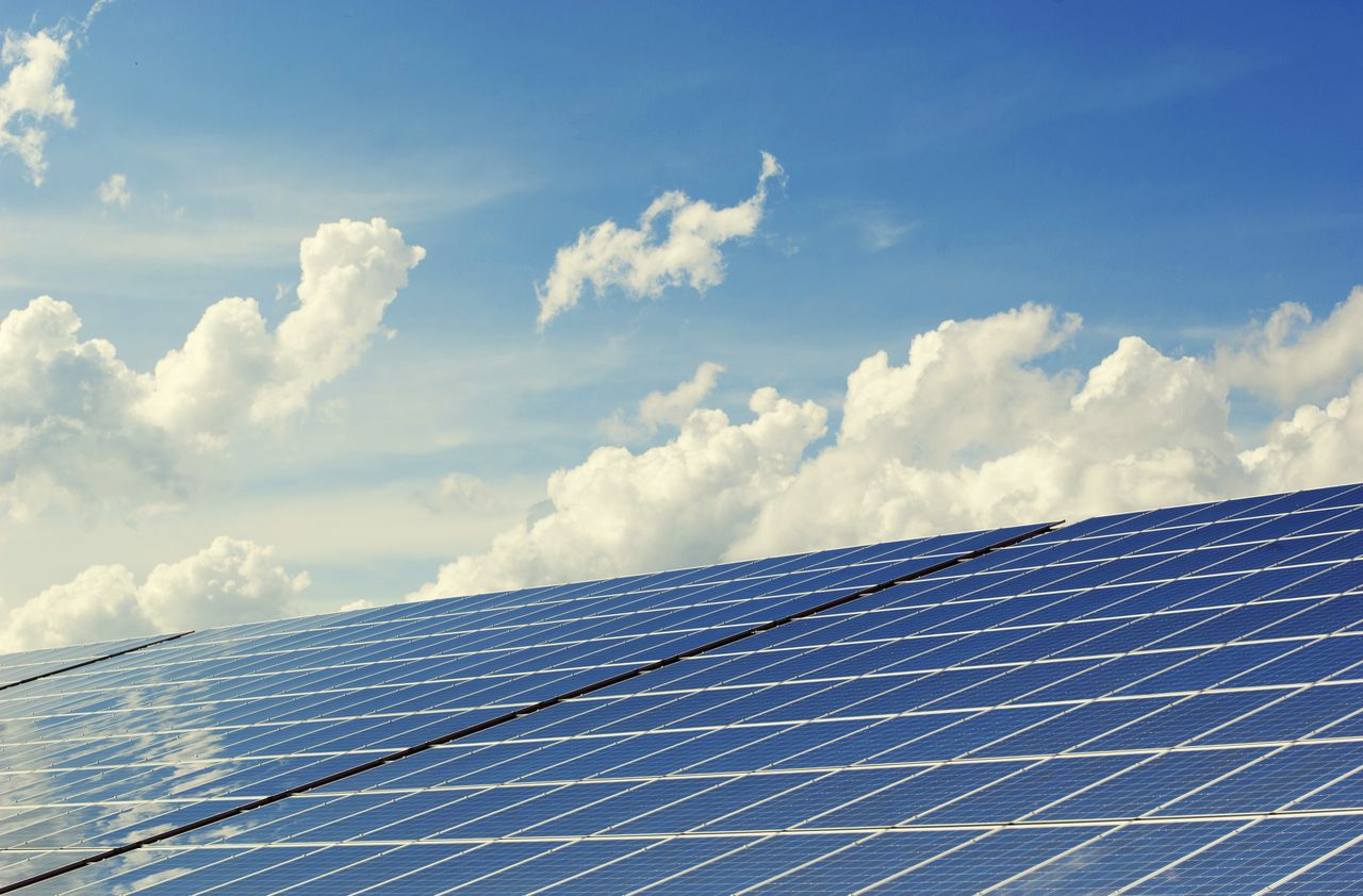 The Art of Drawing Readers In: Your attractive post title goes here Sleek modern solar panels under a vibrant blue sky with clouds, symbolizing clean energy.